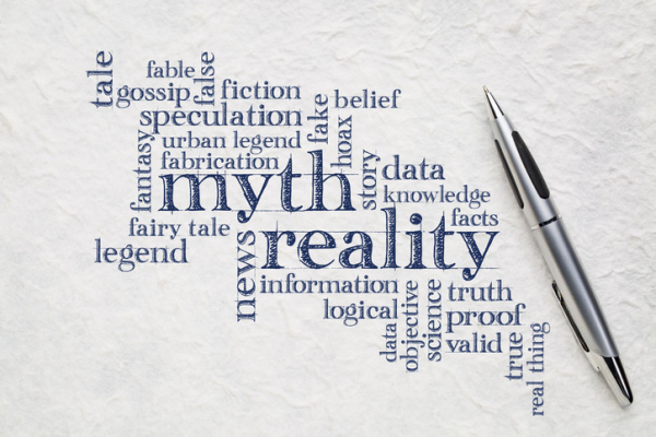 A word cloud illustrating "myth" and "reality" in blue words against white background with silver pen; contrasting phrases include "urban legend," "data, "fake," and "proof"